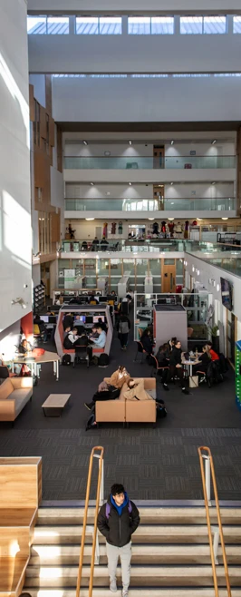 Interior view of Glasgow Kelvin College Springburn Campus showing main atrium with students studying, relaxing, and moving through open-plan spaces. Interior view of Glasgow Kelvin College Springburn Campus showing main atrium with students studying, relaxing, and moving through open-plan spaces.